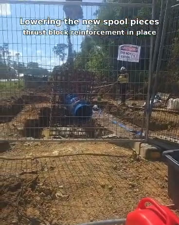 New DN450 spool piece being lowered into the trench, thrust block reinforcement in place